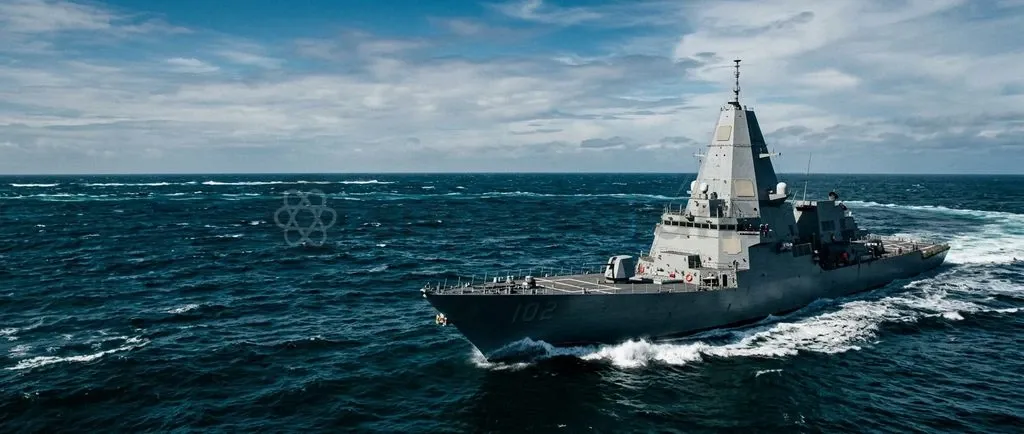 A modern naval combatant equipped with an enclosed integrated stealth mast operating in open waters.